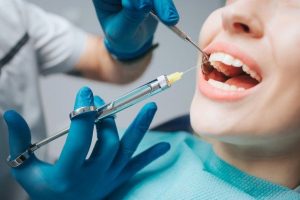پزشک دندانپزشک در حال معاینه بیمار در مطب دندانپزشکی مجهز